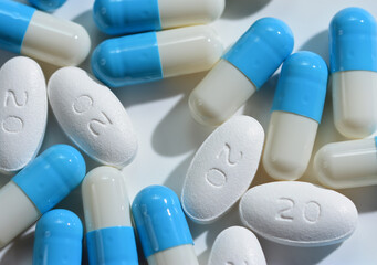 Atorvastatin Film Coated Tablets 20mg  and Omeprazole capsules blue and white grouped on white background