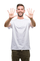 Naklejka premium Young handsome man over isolated background showing and pointing up with fingers number ten while smiling confident and happy.