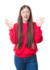 Young Chinese woman over isolated background wearing glasses crazy and mad shouting and yelling with aggressive expression and arms raised. Frustration concept.