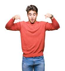 Young handsome man over isolated background Pointing down with fingers showing advertisement,...