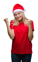 Young caucasian woman wearing christmas hat over isolated background very happy and excited doing winner gesture with arms raised, smiling and screaming for success. Celebration concept.