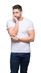 Young man wearing casual white t-shirt over isolated background thinking looking tired and bored with depression problems with crossed arms.