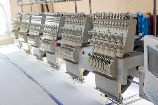 A large industrial embroidery machine in a sewing workshop, representing advanced textile production and craftsmanship. small business, embroidery, fashion branding, and national clothing manufacturin