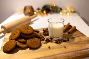 homemade gingerbread cookies with a glass of milk and spices: anise, cloves and cinnamon. traditional christmas dessert, christmas and new year celebration