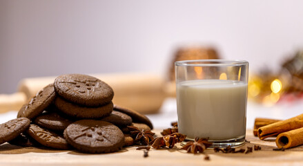 homemade gingerbread cookies with a glass of milk and spices: anise, cloves and cinnamon. traditional christmas dessert, christmas and new year celebration