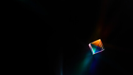 A glass dichroic prism on a black background
