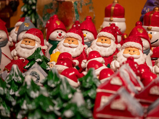 Una multitud de figuritas de cerámica de Papá Noel con sombreros rojos y barbas blancas se exhiben para la venta en un mercado de decoración navideña