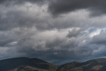 View of hills under rainy clouds