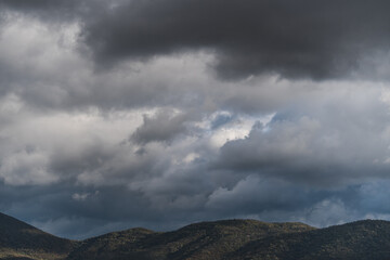 View of hills under rainy clouds