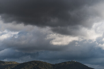 View of hills under rainy clouds