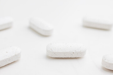 White supplement pills close up. Dietary supplement. Alternative medicine.