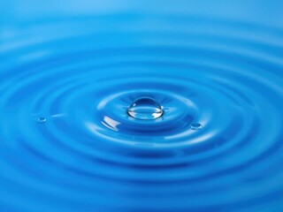 Water drops glistening on a vibrant blue background, creating a calming and refreshing aesthetic, condensation, ripple, macro