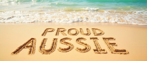 Proud Aussie written on beach sand with ocean waves