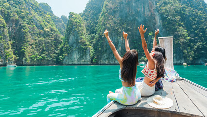 Summer travel nature beach holiday vacation. Group of Happy Asian woman sit on wooden boat passing...
