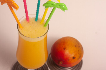 glass of mango juice with colorful mixers