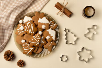 Plate with gingerbread and cutters on beige background. Christmas concept. Flat lay, top view