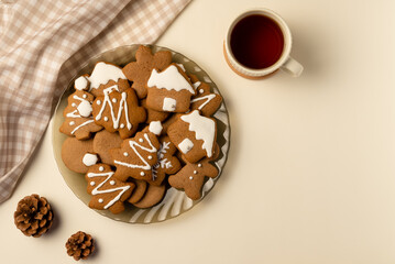 Coziness composition with gingerbread and cup of tea on beige background. Christmas concept. Flat lay, top view.
