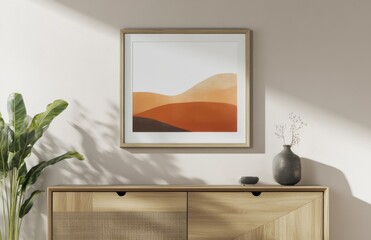 Photo of a wooden blank frame hanging above an oak sideboard with minimal decor and a plant in front, creating a simple, elegant, and modern interior design.