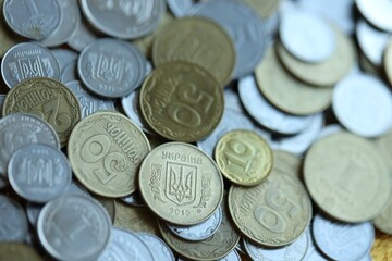 Metal coins of Ukraine of different denominations are scattered. Money texture, business background.