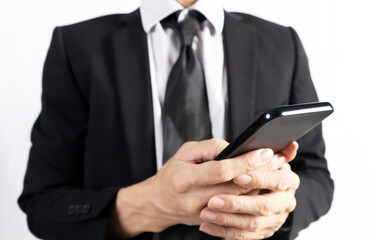 Businessman in black suit standing holding mobile phone to view work data and check work