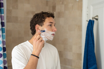 Focused Young Man Shaving Beard