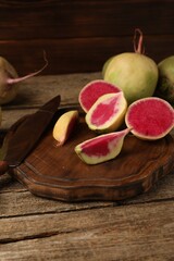 Fresh turnips and knife on wooden table, closeup