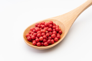 木のスプーンに載せたピンクペッパー