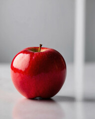 Elegant Red Apple on Smooth White Table for Bright Minimalist Display Fruit Presentation Photo