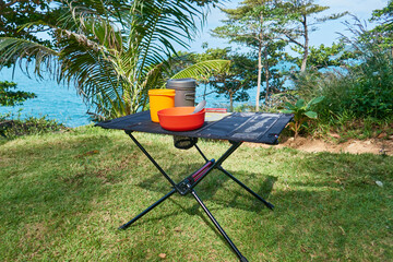 ultralight kitchen set for traveling on a folding table, in nature with a tropical view