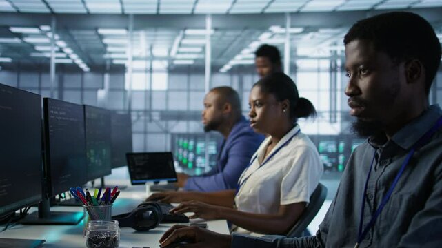 Team leader in server room teaching intern to develop disaster recovery plans ensuring minimal downtime. IT specialist in data center assisting worker in monitoring performance, camera A
