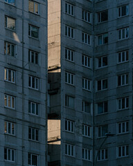 Facade of Soviet-era panel apartment building with shadow patterns. Urban architecture photography. Brutalist design concept for urban exploration.