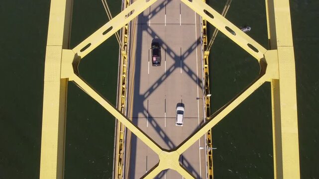 Capture the dynamic essence of Pittsburgh with this aerial drone footage over the George Westinghouse Bridge. The camera offers a captivating view from above, showcasing a steady flow of traffic.
