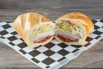 A view of a deli hoagie, featuring turkey, ham and bacon.