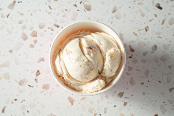 A top down view of a scoop of honey butter ice cream in a cup. © DAVID