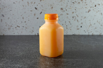 A view of a bottle of orange juice, in a menu item setting.
