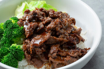 A closeup view of a teriyaki beef rice bowl.