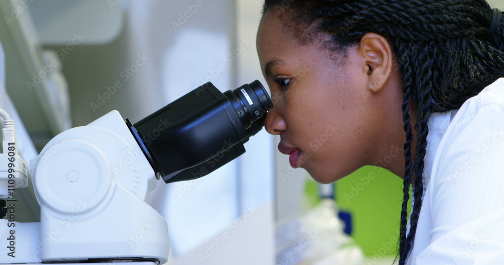 Poster scientist looking through microscope in laboratory
