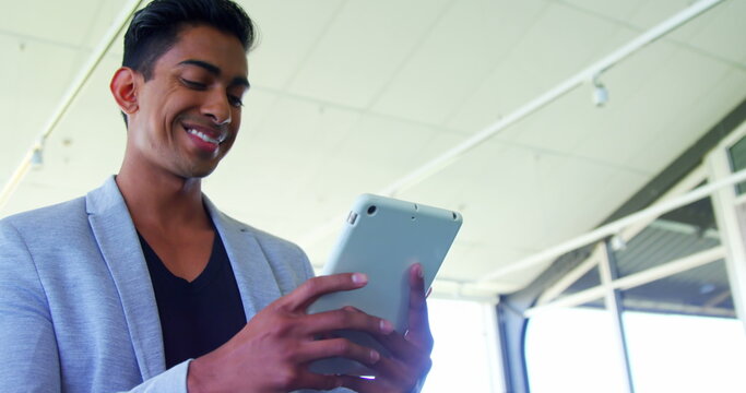 Smiling executive using digital tablet in office