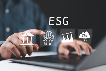 ESG environmental, social and governance. Man using laptop with ESG icons on virtual screen for world sustainable environment concept.