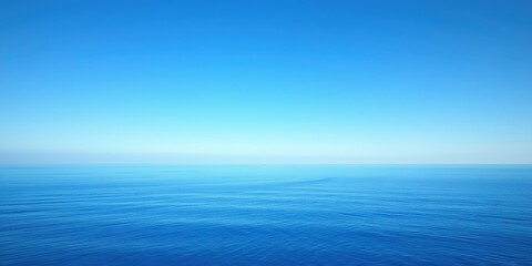 Obraz premium Vast blue ocean with a clear, vibrant sky above, showcasing a serene and peaceful atmosphere.