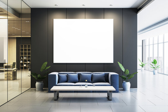Modern office waiting area with large blank digital display on dark wall, blue sofa, and coffee table with decor, clean design. 3D Rendering