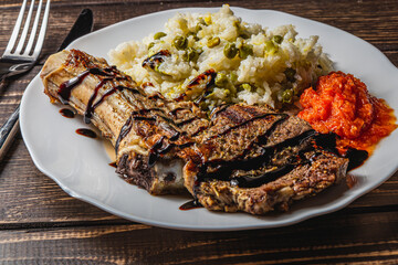 entrecote on the bone with rice and vegetables and spicy tomato sauce