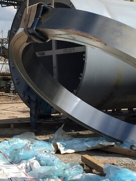 welding process, industrial setting, worker on scaffolding, precision repairs, metallic pipelines, industrial tools, welding equipment, heavy industry, industrial welding, scaffolding work, engineerin