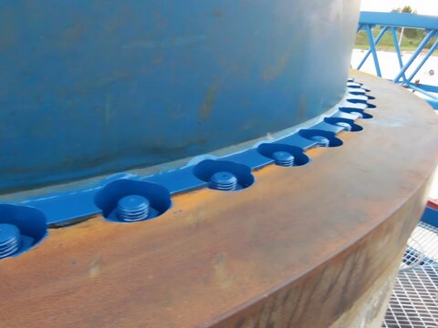  Industrial bolts and metal structure painted blue, showcasing precise engineering and durability in heavy industry.

