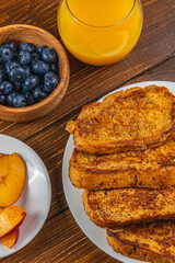 French toast on a plate with blueberries, orange juice, nectarine for breakfast