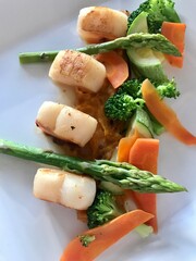Scallops and carrots and asparagus restaurant dish