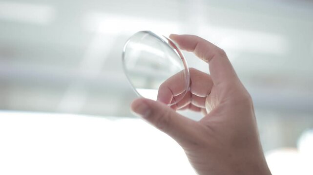 Hand holding lenses, glasses lenses, eyeglass lenses in hand 