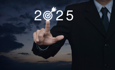 Businessman pressing 2025 letter with goal icon over sunset sky, Business happy new year 2025...