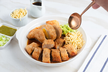 Pempek, traditional food from South Sumatra, Indonesia. This fish-based food is very popular. Served with cuko sauce and cucumber slices. Perfect for recipe, article, catalogue.