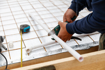 A man is cutting a pipe with a pair of pliers